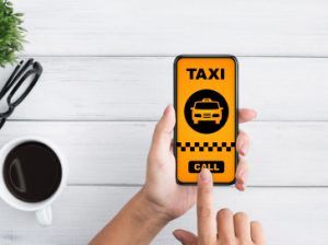 Woman holding a smartphone displaying a taxi app interface, showcasing ride options and location features.